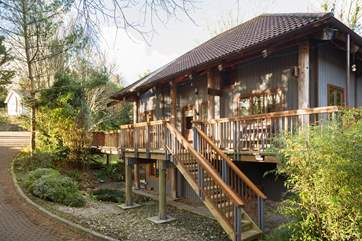 Enter the main house up the steps from the parking area or along the wooden bridge on ground level. The ground floor bedroom and bathroom have a separate entrance.