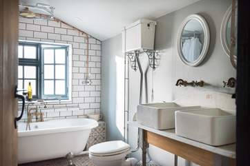 Two sinks, a large shower rose and a shower attachment makes for a very well-equipped bathroom.