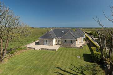 A bird's eye view of the house with the sea in the distance.