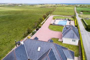 An ariel shot of the house, garage and pool all the way out to sea.