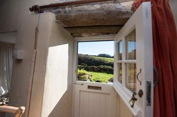 A stable door with a very low lintle leads to the garden and stream.