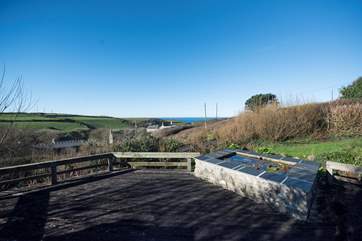 The view from the decked terrace which is flanked by a deep pond and accessed across a small open bridge.