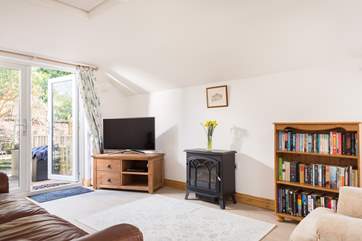 The sitting-room has a large flat screen SmartTV, iPod dock and electric wood-burner, and opens onto the private deck through the French doors.