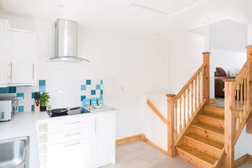 Steps connect the kitchen to the sitting-room and another small flight takes you down to the bedroom and shower-room