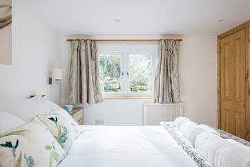 The gorgeous bedroom has a built-in wardrobe and good-size bedside cabinets with plenty of drawer space.