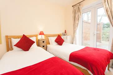 The twin bedroom is located on the ground floor with doors that can open up onto the private decking