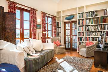 The double height second sitting-room is incredibly light and airy - with plenty of holiday reading and French doors leading out to the terrace.
