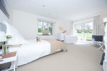 This ground floor bedroom has French windows which open onto the garden.