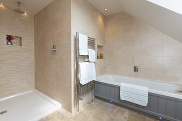 The en suite for the first floor bedroom has a walk-in shower with a rainfall shower head, as well as a bath.