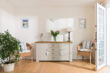 The sun floods into the sitting-room through the conservatory.