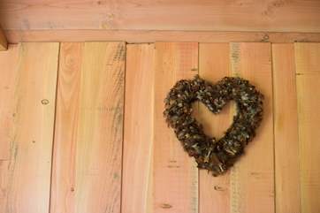 A heart-shaped pheasant feather wreath sits above the bed.