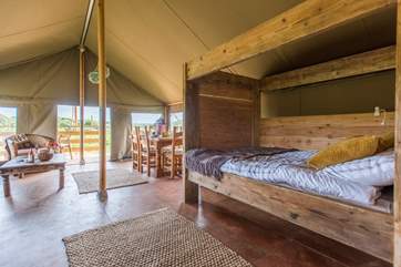 The delightful living area is open plan, complete with cosy cabin bed (Tembo will be similar to Twiga, the neighbouring safari tent pictured).