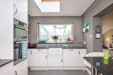 From the kitchen you can look into the conservatory and the views beyond. The utility-room leads off to the left.