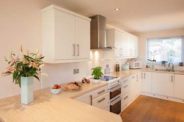 The delightful kitchen with double cooker and wine fridge is a beautiful space to cook and entertain the family