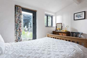 This bedroom has a door out onto the patio part of the garden.