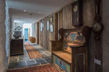 The panelled hallway is lined with upcycled wooden boards and an eclectic mix of the Owners' pictures alongside this 'one of a kind' wooden bench.