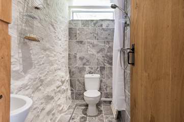 The wet-room shower has been creatively built around the original and wonky outside wall of the barn.