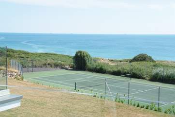 A view from the apartment across the gardens and the neighbours' tennis court to the beach beyond.