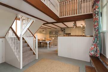 The staircase separates the living area from the kitchen/dining area.