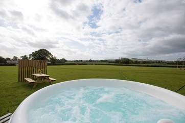 The bubbling electric hot tub sits proud on the deck just to the side of the tent.