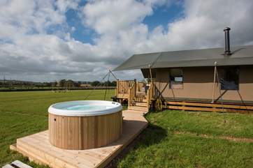 Steps from the wide veranda lead down to the decked hot tub area.