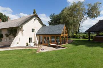This historic farmhouse has a contemporary twist with this oak-framed garden/dining-room.