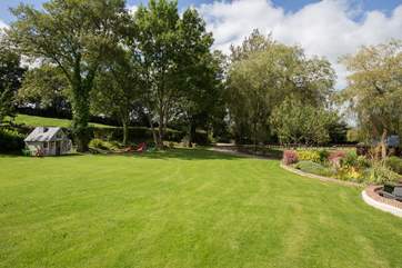 The top lawns have a delightful Wendy House for children to play in (the raised flower bed in front of the house to the right of the photo includes a shallow goldfish pond, so please take care)