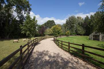 There is a sweeping driveway up to the farmhouse.