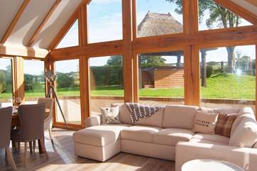 The L-shaped sofas in the oak framed extension create an additional social space with direct access to the gardens.
