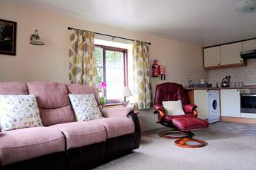 The open plan living-room is very comfortable with a reclining sofa and easy chair.