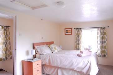 The spacious, bright bedroom has an en-suite bathroom.