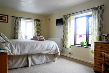 Two big windows make the bedroom light and bright.