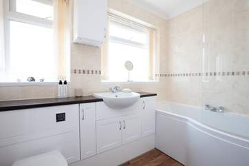 The bathroom has a modern white suite.