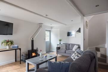 The open plan living-room with sofas around the wood-burner is perfect for relaxing with friends or family.