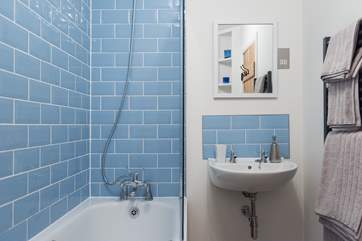 The en suite bathroom a bath with a fitted shower above.