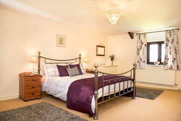Wonderfully spacious bedroom 1 has a king-size double bed, a gorgeous bedstead and a handy vanity unit.