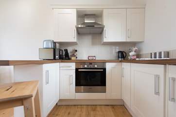 The kitchen is complete with an induction hob, and is compact, light and airy.