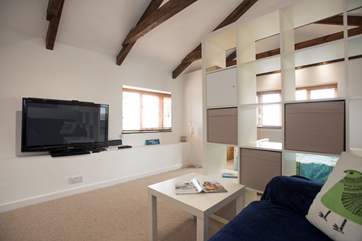 A large TV is easy to watch from bed or in the sitting-area.