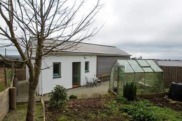 A winter view of the back of The Tractor Shed, in summer guests can help themselves to fresh produce from the greenhouse.
