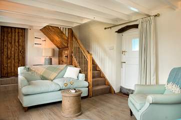 The cosy sitting-room with the stairs leading up to bedroom 2 and the family bathroom.