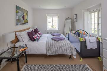 There is room for a cot at the end of the bed in this lovely bedroom.