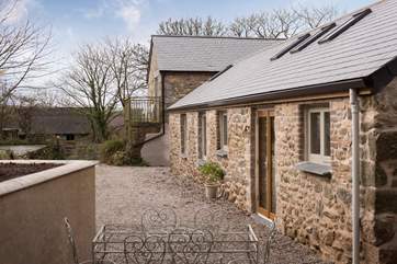 The parking area is to the side of the barn and there is another holiday cottage by the lane.