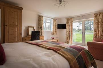 Bedroom 4 has a king-size double bed (5'), a sitting-area with sofa and Smart TV, and patio doors out to the garden.