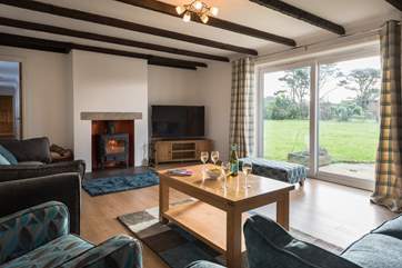 The main sitting-room has a wood-burner and doors out to the garden.