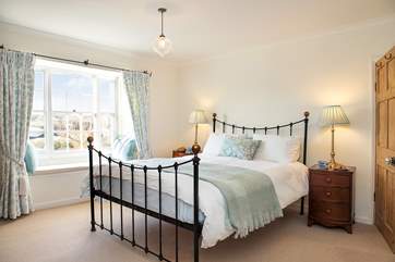 Bedroom 1 with pastel blue shades and a lovely king-size bedstead.