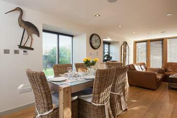 The dining-table is set to one side of the room which has plenty of light and space.