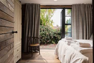 Doors open from the bedrooms and living space onto the garden and hot tub deck.