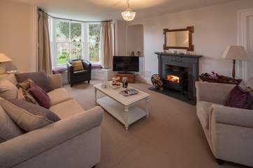 The sitting-room is cosy yet spacious, with stunning views across over the garden and out over the water.