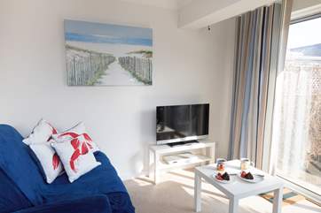The light and airy living area is a great space to put your feet up, open the doors and let the sea air come through.