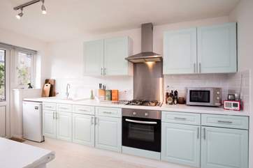 From the lovely and bright kitchen, there are steps down to the garden, so you can watch the children play.